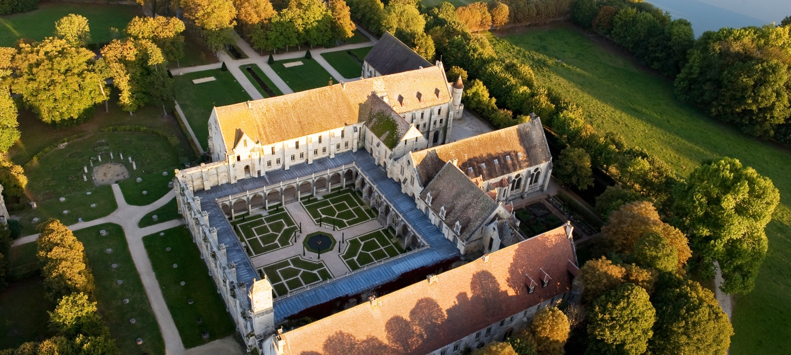 Photo de l'abbaye de Royaumont prise du ciel avec toute le paysage de verdure environnant