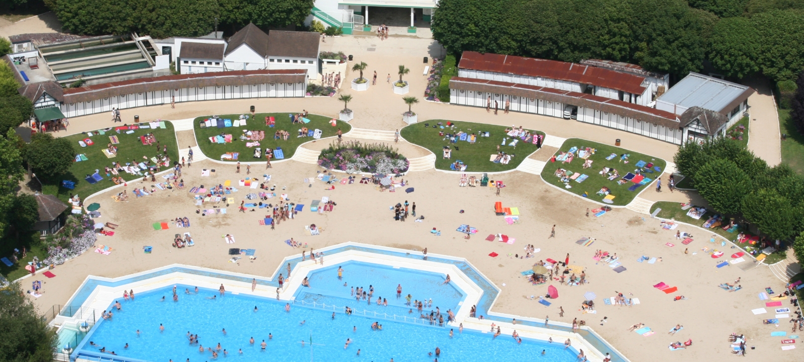 Photo de la plage de L'Isle-Adam vue du ciel en haute saison, l'été, avec plusieurs baigneurs venus en profiter.