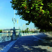 Photo de la promenade autour du lac d'Enghien-les-Bains avec vue sur le casino Lucien Barrière sous un ciel bleu