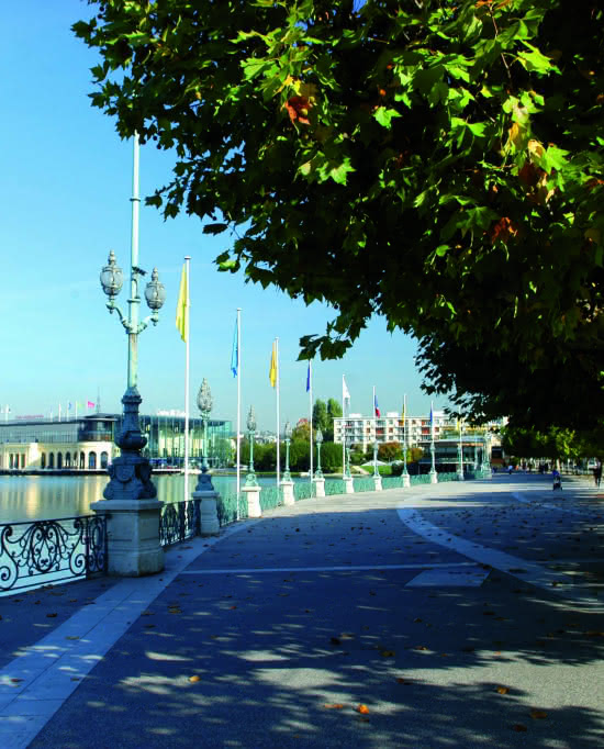 Photo de la promenade autour du lac d'Enghien-les-Bains avec vue sur le casino Lucien Barrière sous un ciel bleu