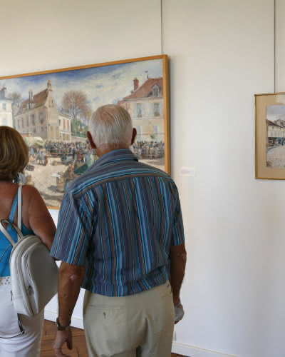 Photo de deux personnes regardant des tableaux pendant leur visite du musée Pissarro à Pontoise