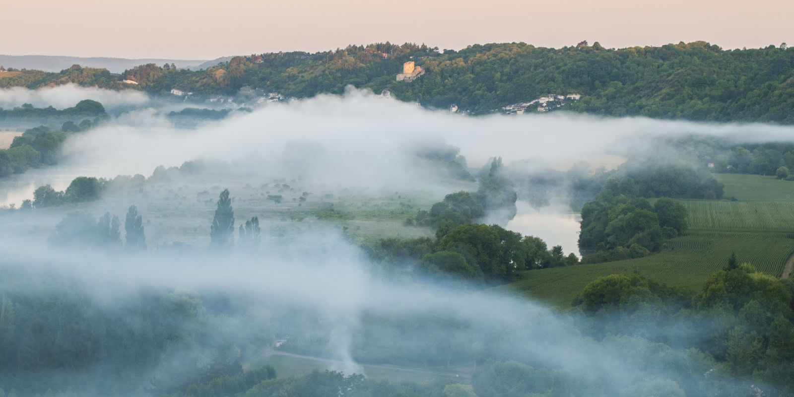 Photo de La Roche Guyon et de ses environs prise depuis une montgolfière avec une brume épaisse et blanche