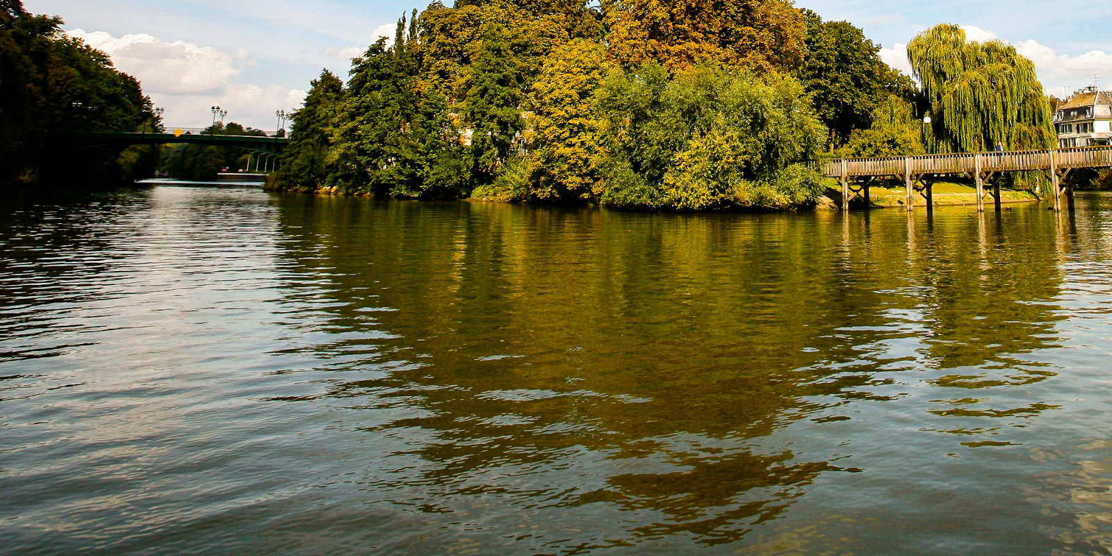 Photo de l'Isle Adam et de ses îles et ponts prise depuis un bateau sur l'Oise par beau temps