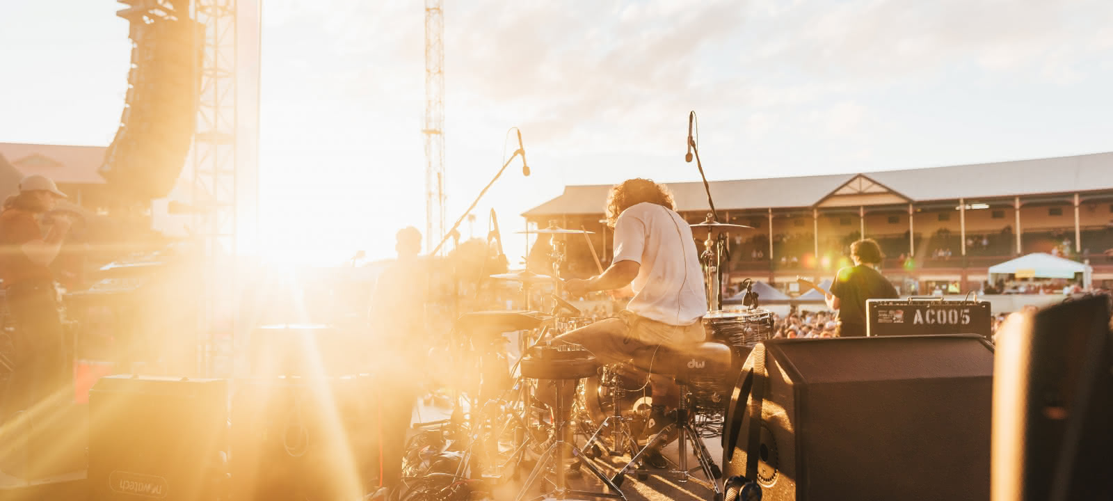 Photo d'un groupe de musique jouant devant un stade bondé sous un ciel bleu