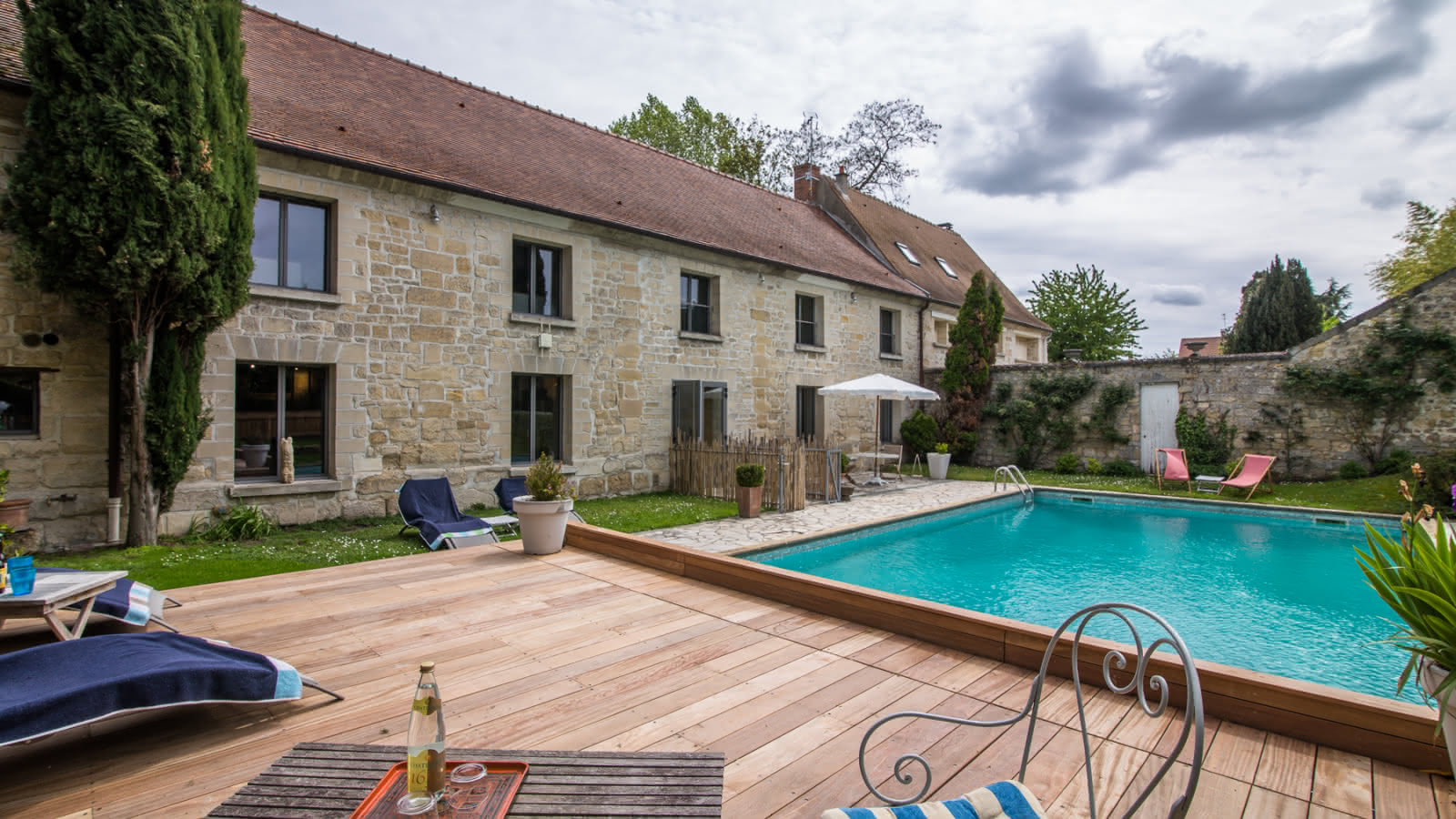 Photo de la piscine et sa terrasse de la chambre d'hôtes le Domaine de Mona à Cergy près de l'Ile de Loisirs de Cergy-Neuville