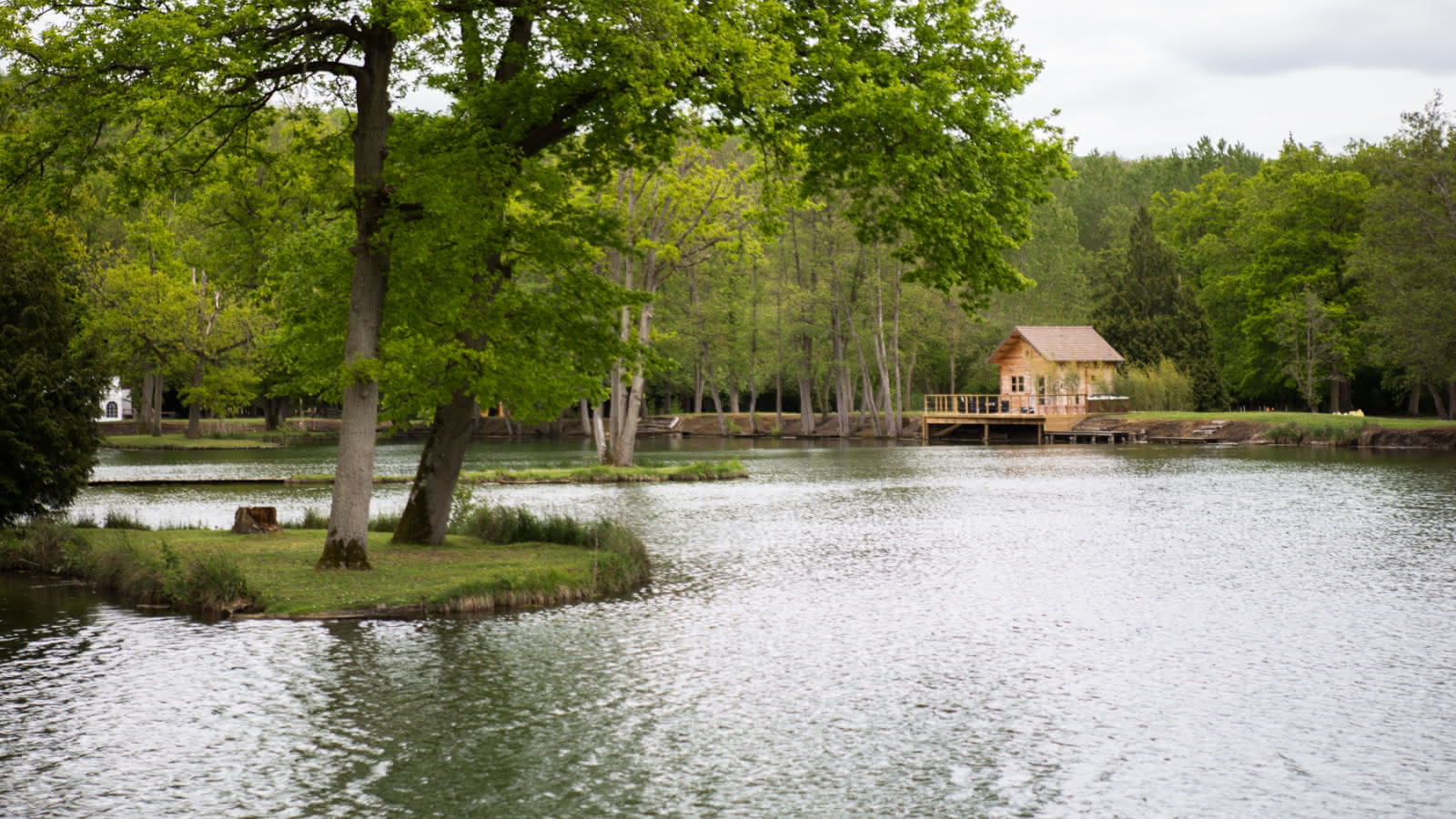 Photo montrant un des chalets des Etangs de la Palombière et un de ses lacs à Montreuil-sur-Epte dans le Vexin français
