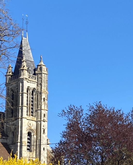 Clocher d'une église et avion dans le ciel à Goussainville