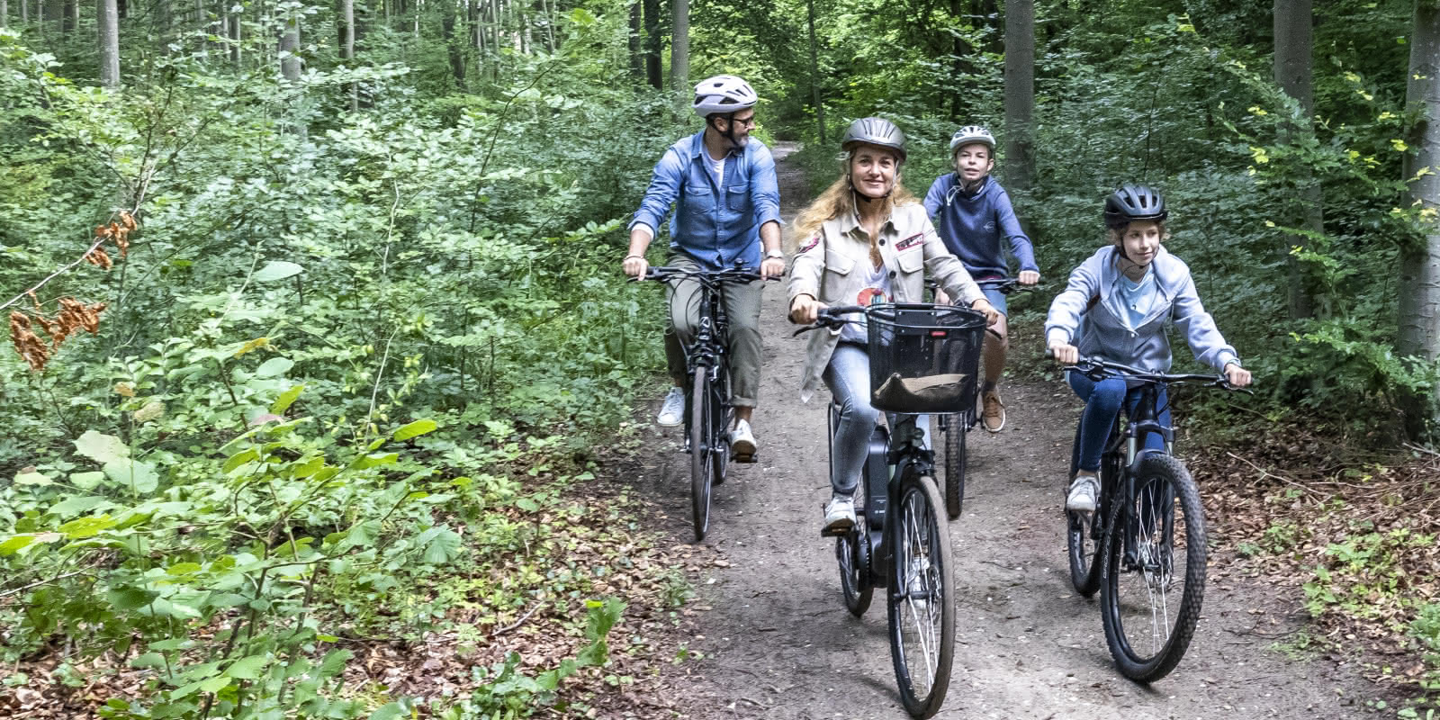 Famille en balade à vélo dans la forêt