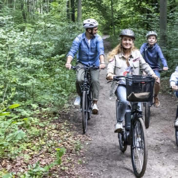 Famille en balade à vélo dans la forêt